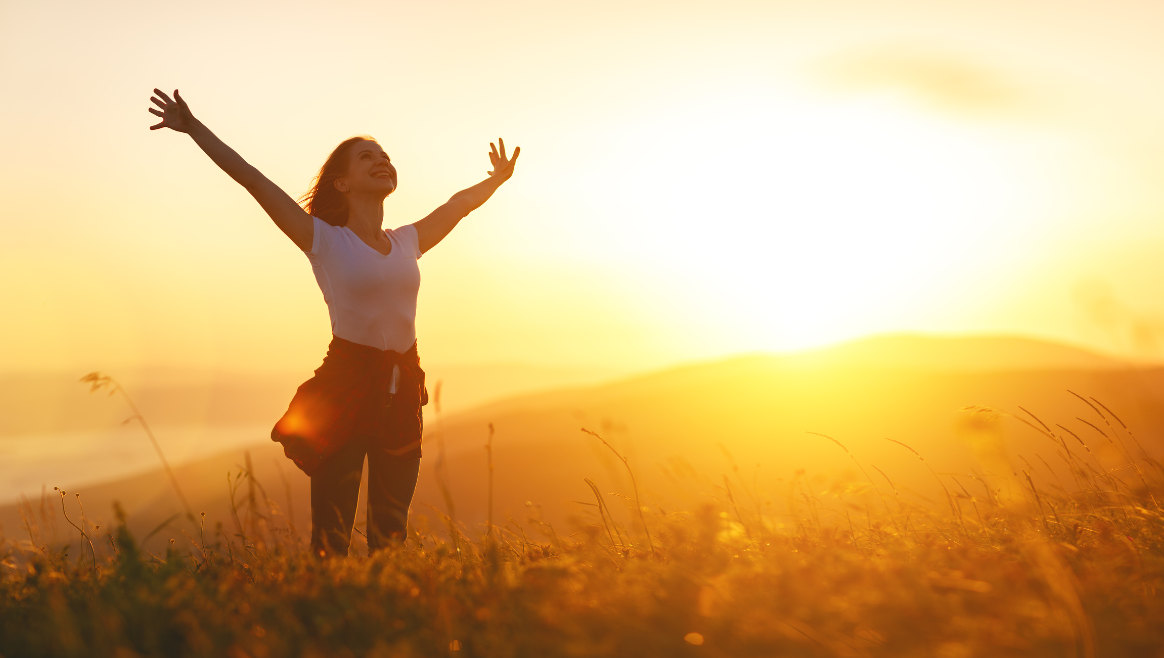 Happy woman on sunset in nature iwith open hands